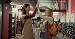 Women, friends and high five with books at college, library and celebration for goals, study or results. Girl, university students and happy with success, cheers or motivation for learning at academy