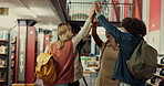 Laughing, friends and group in library, high five and gesture for achievement, celebration or proud. Success, learner and people with victory for education, university and teamwork for scholarship