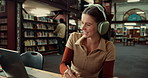 Laptop, woman and student with headphones in library studying for university exam with textbooks. Education, computer and female person writing with learning for college test or assignment on campus.