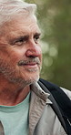 Senior man, hiking and thinking in woods with smile, adventure or sightseeing on vacation in summer. Person, happy and outdoor with perspective, view or reflection for trekking in forest in Germany