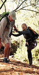 Senior couple, hiking and holding hands for help on hill, happy and adventure on vacation in woods. People, support and balance with walk, smile and guide for trekking in retirement in Australia