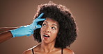 Eye brow, filler and wow with black woman in studio for antiaging treatment or plastic surgery. Beauty, hands of surgeon and surprise with African person in clinic for cosmetic procedure or injection
