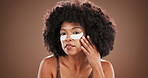 Studio, woman face and check with eye mask for skincare, facial treatment and collagen with smile. Afro, African person and portrait with patches for beauty, cosmetics or space in isolated background