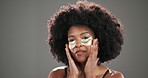 Face, skincare or black woman with space, eye patch or cosmetics for glow, beauty or shine. Depuff, studio mockup or afro girl on grey background with pads, anti aging dermatology or hydration gel