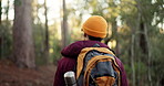 Man, back view and hiking with bag in forest for adventure, outdoor journey or trail in nature. Male person, hiker and walking with backpack or trees on natural path for trekking or fitness in woods