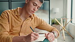List, notebook and writing with man on sofa for inspiration, journal prompt and reminder. Reflection, agenda and planning with person in living room of home for diary, schedule and brainstorming