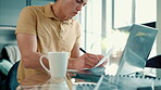 Man, laptop and document with coffee for remote work at home for information, research and typing. Male person, drinking tea and technology with paperwork for freelancing and account management