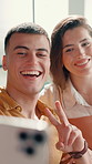 Selfie, laugh and couple on sofa with peace sign for social media, online post and profile picture. Love, dating and man with woman take photo with emoji for bonding, fun and relax in living room