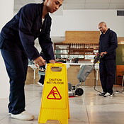 Janitor, team and office with caution sign, hygiene service and wet ...