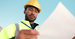 Low angle, man or builder on site for floor plan, engineering inspection or project management. Reading, think or contractor in construction job for city development with check, review or blueprint