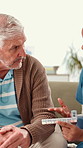 Nurse, senior man and discussion with pills, prescription and healthcare for retirement. Patient, caregiver and pensioner in nursing home, rehabilitation or care for medical consultation or service