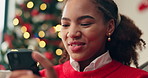 Christmas, woman and laughing with phone on sofa for funny holiday text, season greeting or chat. Xmas, happy and african person with smartphone in home for social media meme, relax or vacation break