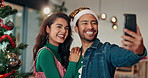 Selfie, couple and celebration of Christmas, tree and profile picture for festive season and memory. Home, man and laughing with woman in living room, photography or smile for social media on holiday