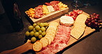 Cheese board, cold meat and fruit with crackers for snack, food or charcuterie for catering. Healthy, grapes and gourmet selection with fresh ingredients on wooden surface for nutrition or meal