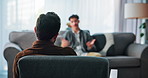 Back, talking and man on sofa with therapist for consulting, counseling and therapy session. Psychology, mental health and psychologist with patient for emotional support, advice and help in office
