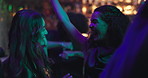 Happy, women and friends dancing at nightclub with energy, movement and rhythm at disco event. People, laugh and reunion for New Years celebration, music festival and freedom by bonding for nightlife