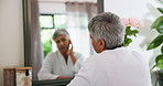 Mirror, senior woman and sad with inspection, skincare and cosmetics results. Pensioner, depression and elderly lady with reflection, grooming or treatment fail for wrinkles or dermatology in house