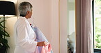Senior woman, clothes and choice with mirror, excited and happy for fashion, style and morning start. Back of person, idea and decision with outfit, garment or shirt in bedroom for wardrobe in house