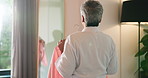 Mature woman, clothes and choice with mirror, excited and happy for fashion, style and morning start. Back of person, smile and decision with outfit, garment or shirt in bedroom for wardrobe in house