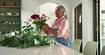 Arrangement, happy and mature woman with flowers in vase for growth, natural bloom and plant care. Prune, home and person with bouquet, floral and blossom for display, decoration and aesthetic
