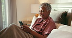 Phone, smile and mature woman in bed with social media, comic or comedy video on the internet. Happy, technology and senior female person in scroll on mobile app with cellphone in home for break