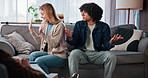 Therapy, angry and couple on sofa talking for relationship help, counseling and partnership issue. Psychology, upset and man with woman in discussion, argument and conflict for emotional burnout