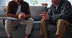 Therapy, writing and men on sofa in office for consulting, counseling session and support. Psychology, mental health and therapist with patient with notes for diagnosis, listening and evaluation