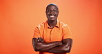 Crossed arms, happy and face of black man on orange background with smile, style and confidence. Aesthetic, creative and portrait of person with fashion, trendy clothes and cool outfit in studio