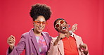 Face, dancing and women in studio, friends and bonding together on red background. People, fashion and models with smile, stylish clothes and laughing with movement, energy or celebration with rhythm