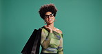 Face, shopping bag and happy woman with glasses for fashion, sales and discount. Smile, shopaholic and African customer with gift for Black Friday, promotion and mockup space on studio background