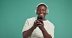 Headphones, dance and black man with phone by studio background for listening to music online. Happy, energy and African person with audio tech and cellphone for streaming playlist by mockup space.