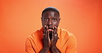 Black man, studio and shocked face or expression on orange background for wow, rumor or gossip. Body language, scared male person and space for surprise, fear or bad news or announcement with regret