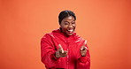 Face, finger guns and black woman in studio, smile and good news on orange background. Portrait, happy person and model with hand gesture, welcome and announcement for discount deal, prize and sales