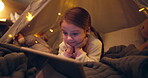 Kid, tablet and night in tent at house for streaming movies, watching cartoon and bedtime routine. Child, relax and digital app for surfing internet, multimedia and reading ebook for entertainment