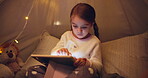 Kid, relax and tablet in tent at house for streaming movies, watching cartoon and bedtime routine. Child, night and digital app for surfing internet, multimedia and reading ebook for entertainment