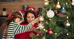 Child, mother and decorations on tree for Christmas tradition, celebration and festive season. Smile, woman and kid help with ornaments, sparkle aesthetic and family bonding on xmas holiday at house
