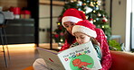Christmas, mom and bonding with child, book and reading fiction story to daughter, break or holiday. Happy, woman and literature for girl in living room, growth and development on festive season