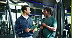 Conversation, man and personal trainer with tablet in club for planning of training program. App, consulting or exercise with client and fitness coach in gym for development of workout schedule