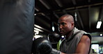 Exercise, punching bag and workout with black man boxer in gym for combat sports or fight. Boxing, fitness and technique with athlete in health club for conditioning, skill or strength training