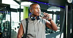 Athlete, black man and leave gym with drinking water for hydration, workout performance or fitness. Sports bag, person or walking with liquid bottle for body detox, thirsty or nutrition for recovery