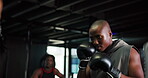 Training, boxer and man with coach, gym or fight with gloves for self defense, wellness or practice. Boxing, fitness and athlete with personal trainer for sport, people or preparation for competition