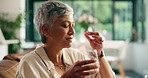 Elderly woman, pills and drink water at house for supplements, prescription and chronic illness. Senior person, smile or thinking with medicine tablet, daily routine and wellness benefits of recovery
