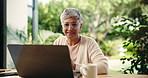 Coffee, laptop and remote work with mature woman in home office for small business research. Computer, glasses and reading with freelance employee searching information in apartment for startup job