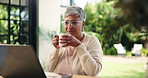 Drink, laptop and remote work with mature woman in home office for small business research. Coffee, computer and glasses with freelance employee reading information in apartment for startup job