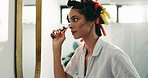Woman, mirror and jade roller in bathroom to relax with massage product and routine. Morning, reflection or female person in home with facial tool for lymphatic drainage, beauty or natural skincare