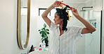 Woman, happy and hair curlers in mirror of bathroom for heatless styling, getting ready and beauty. Morning, person and haircare in home for self care maintenance, grooming and pinup curls routine