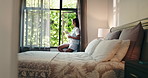 Home, woman and phone by window in bedroom for reading morning news, check weather or browsing. Relax, person and coffee with smartphone in apartment for social media, internet scroll or text message