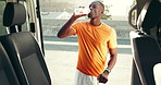 Man, fitness and break with water in city street for hydration or natural sustainability by vehicle. Active, male person and drinking with mineral liquid for rest, recovery or thirst by car in town