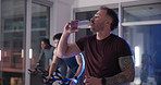Water, gym and man at cycling class with break for intense workout, activity or body training. Sweat, hydration and male person on bicycle machine with cardio exercise for health in sports center.