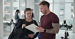 Man, woman and clipboard with sign up in gym, planning and writing for ideas, workout and smile with info. Personal trainer, paperwork and signature for fitness, checklist or agreement for wellness